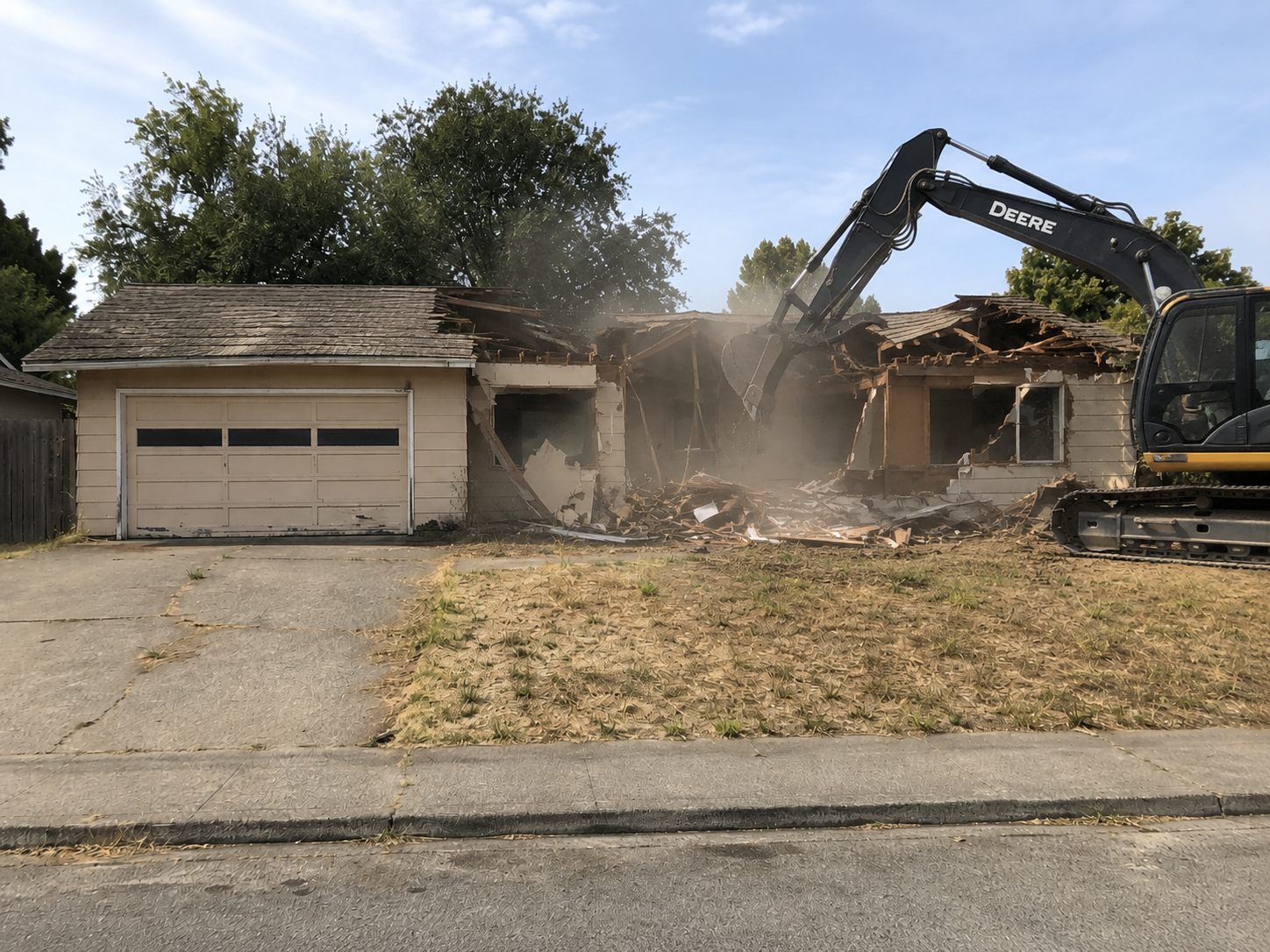 Excavator tearing down the house during demolition