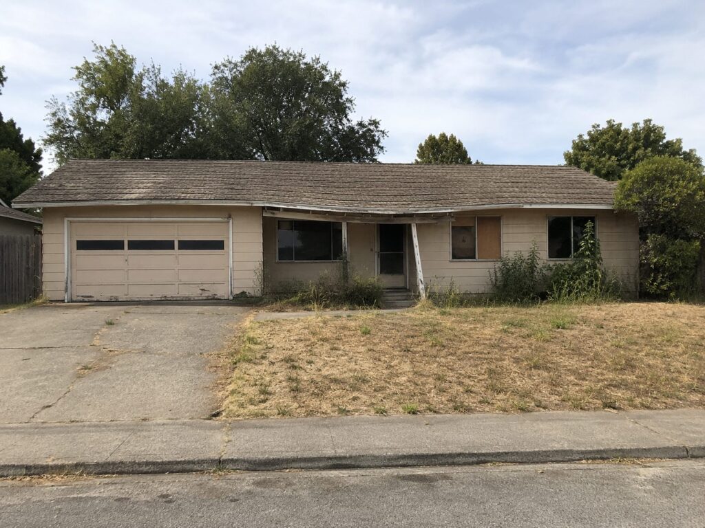 Abandoned single-story house before demolition
