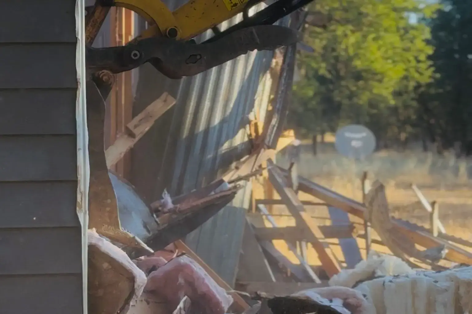 Excavator tearing down a barn structure