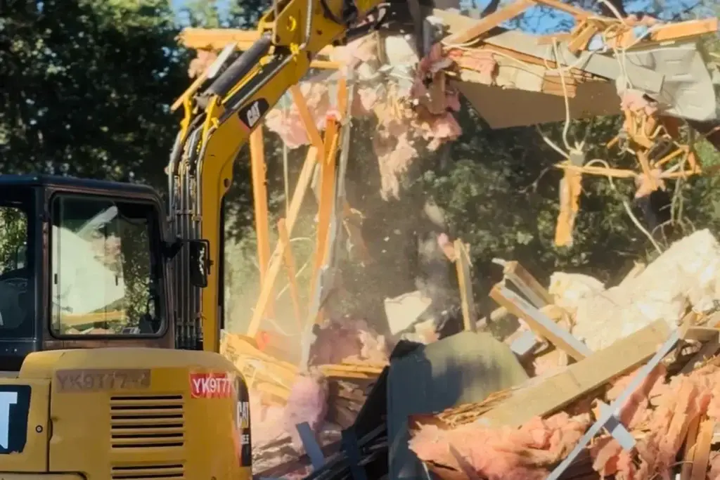 Mini excavator demolishing a house in Northern California