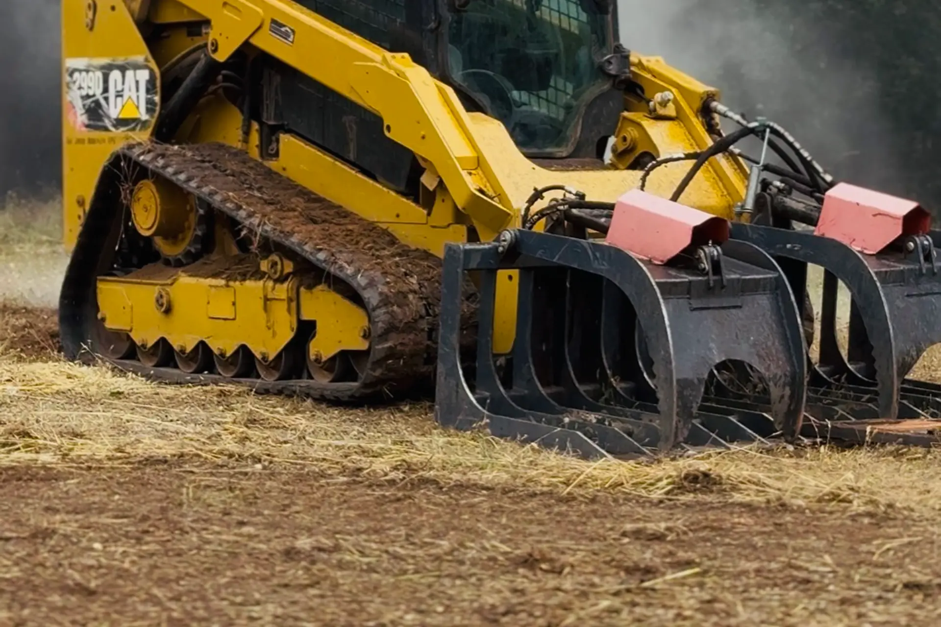 Track loader with grapple clearing land in rural Northern California